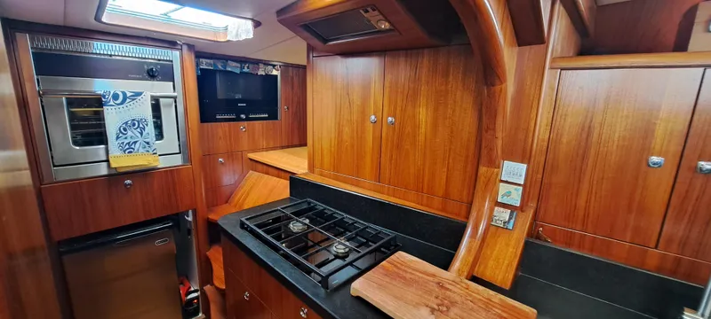 Koa E Kea Yacht Photos Pics Luxurious wooden kitchen interior of 1986 Custom Pinta Exception 53 yacht.