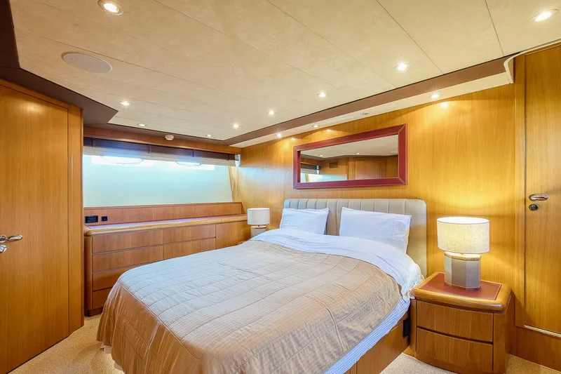 D-force Yacht Photos Pics Luxurious bedroom interior of 1998 Falcon Yachts 86, featuring elegant wood paneling and ambient lighting.