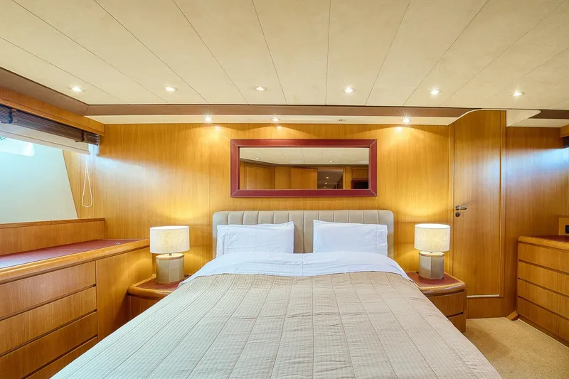 D-force Yacht Photos Pics Luxurious bedroom interior of 1998 Falcon Yachts 86, featuring elegant wood paneling and ambient lighting.