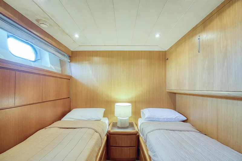 D-force Yacht Photos Pics Twin cabin interior of 1998 Falcon Yachts 86, featuring wooden paneling and cozy lighting.