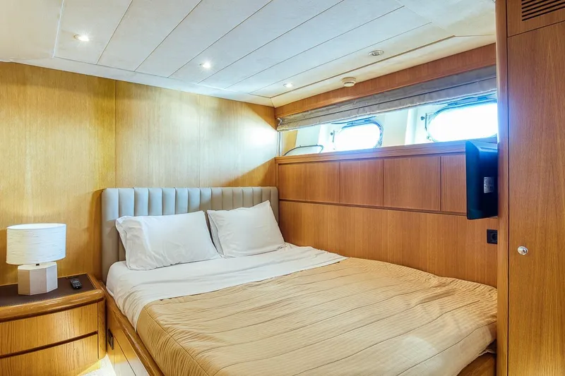 D-force Yacht Photos Pics Luxurious bedroom interior of 1998 Falcon Yachts 86, featuring elegant wood paneling and cozy bedding.