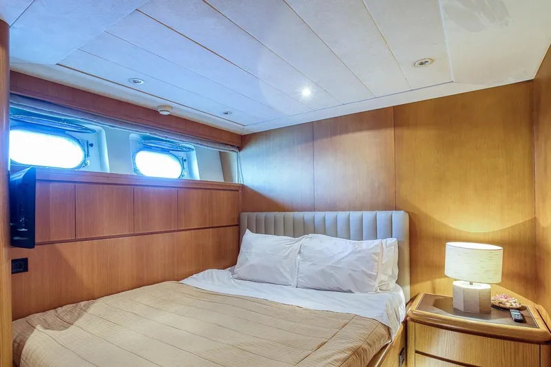 D-force Yacht Photos Pics Luxurious bedroom interior on 1998 Falcon Yachts 86, featuring elegant wood paneling and cozy bedding.
