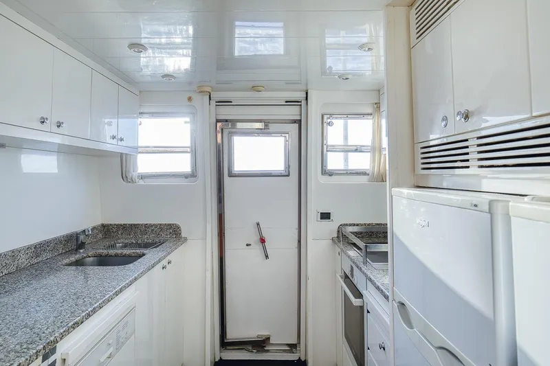 D-force Yacht Photos Pics Luxurious kitchen interior of 1998 Falcon Yachts 86 with granite countertops and modern appliances.