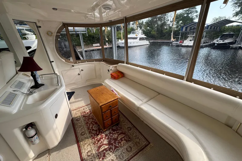 Marlys Kay Yacht Photos Pics Interior of 2004 Sea Ray 390 Motor Yacht with white seating and wooden table.