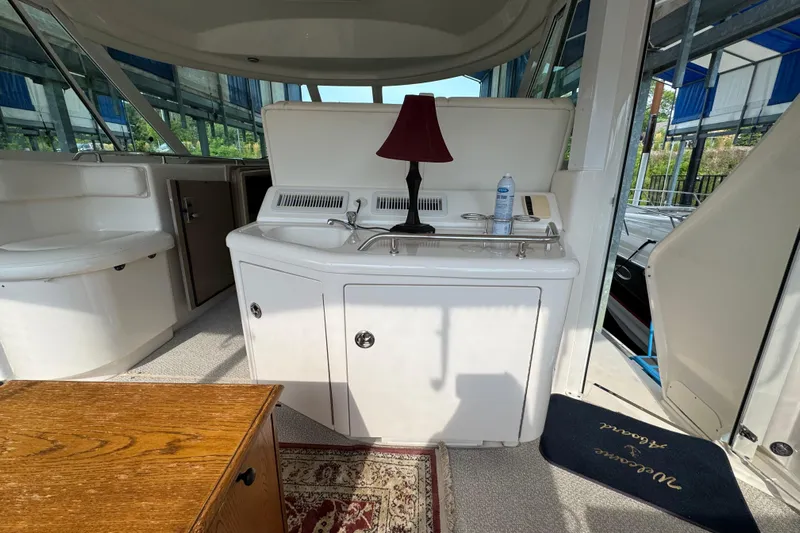 Marlys Kay Yacht Photos Pics Interior of 2004 Sea Ray 390 Motor Yacht with sink, lamp, and seating area.