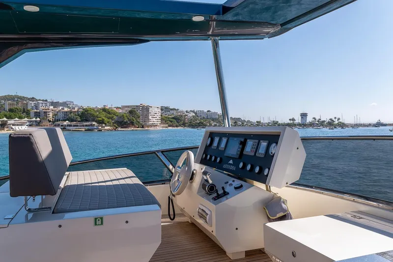  Yacht Photos Pics Cockpit view of 2008 Astondoa 76 GLX yacht with coastal scenery in the background.