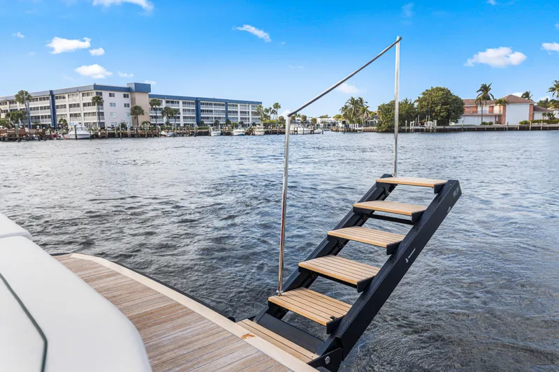  Yacht Photos Pics Staircase on Wally 48 yacht, 2021 model, overlooking waterfront buildings and clear blue sky.