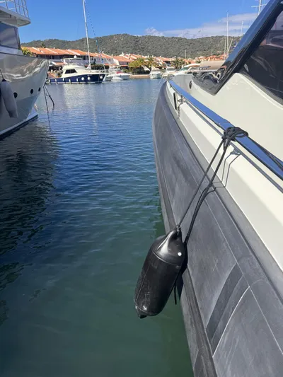  Yacht Photos Pics 2024 SACS Rebel 47 yacht docked in a marina, featuring a black fender.