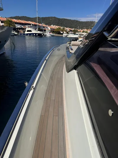  Yacht Photos Pics 2024 SACS Rebel 47 yacht docked in a marina, showcasing sleek design and wooden deck.