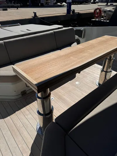  Yacht Photos Pics 2024 SACS Rebel 47 yacht interior with sleek wooden table and cushioned seating.