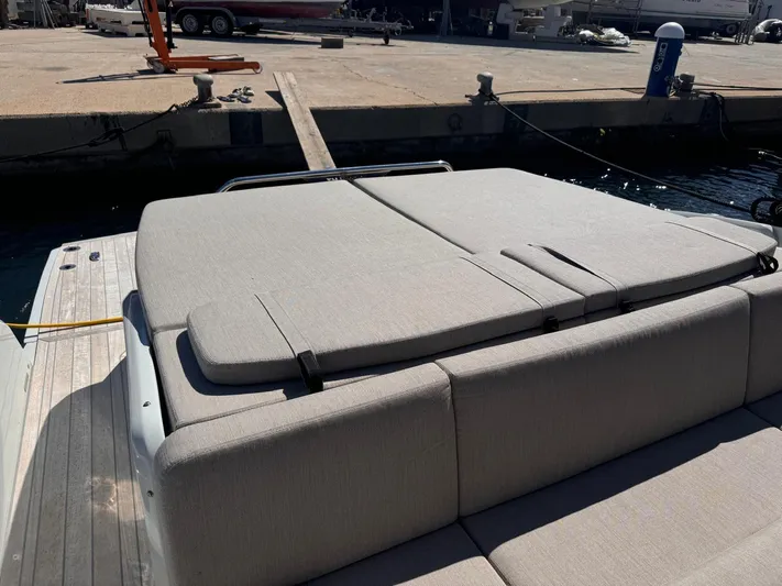  Yacht Photos Pics 2024 SACS Rebel 47 yacht with cushioned sunbathing area at dock.