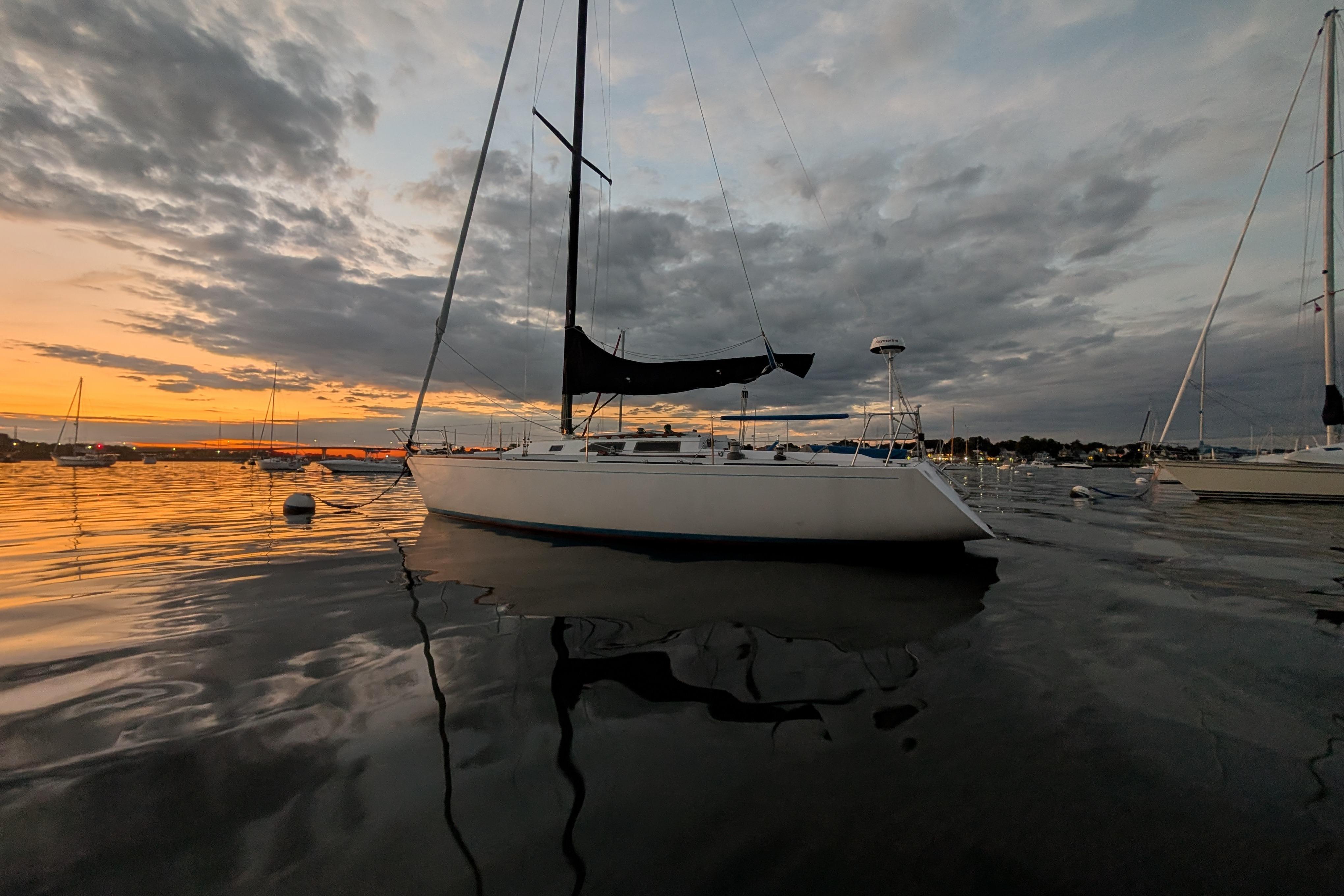 Sailboat on calm water at sunset, Express 37, 1986 model.