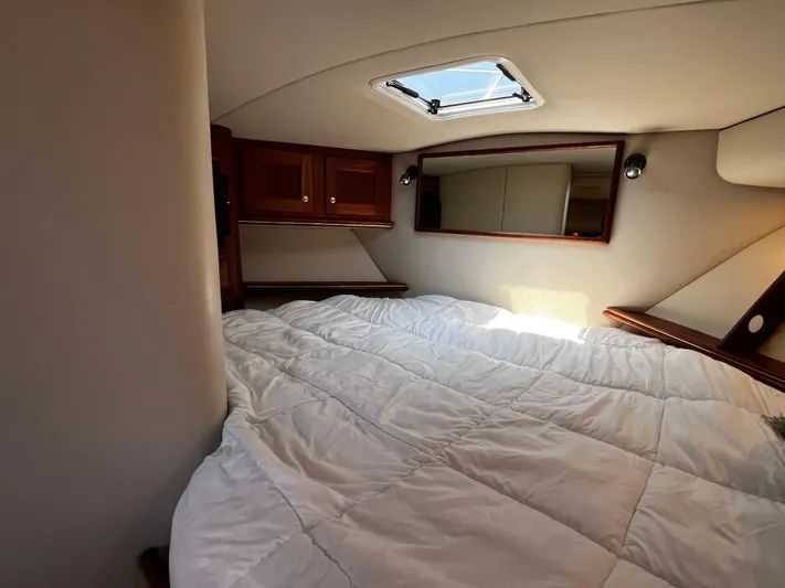 Christine Elizabeth Yacht Photos Pics Cozy cabin interior of 2002 Rampage 38 Express with bed and wooden cabinets.
