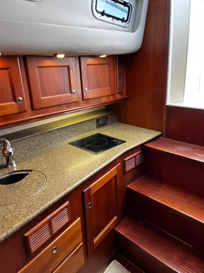 Christine Elizabeth Yacht Photos Pics 2002 Rampage 38 Express yacht interior kitchen with wooden cabinets and countertop.