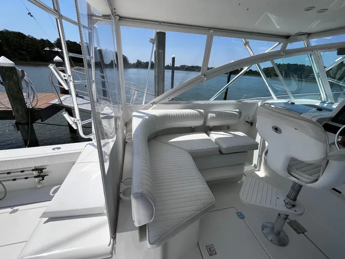 Christine Elizabeth Yacht Photos Pics Interior of 2002 Rampage 38 Express boat with white seating and helm, docked by water.