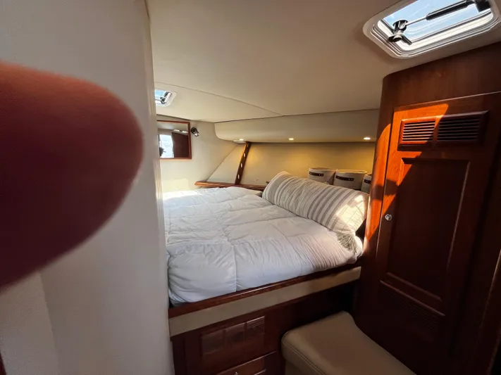 Christine Elizabeth Yacht Photos Pics Cozy cabin interior of 2002 Rampage 38 Express yacht with bed and wooden accents.