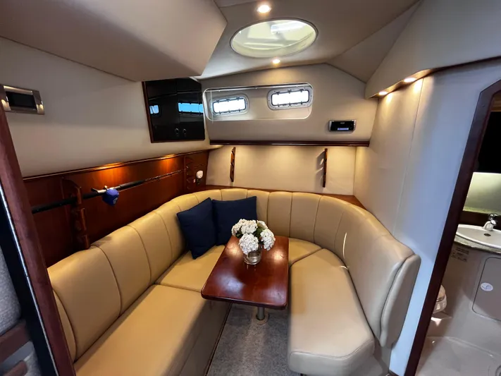 Christine Elizabeth Yacht Photos Pics Luxurious 2002 Rampage 38 Express yacht interior with beige seating and wooden table.