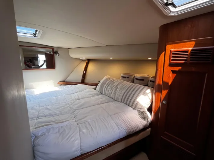 Christine Elizabeth Yacht Photos Pics Cozy bedroom interior of 2002 Rampage 38 Express yacht with plush bedding and wooden accents.