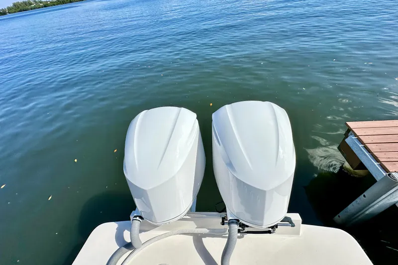  Yacht Photos Pics Twin outboard motors on a 2006 Jupiter 31FS boat by a dock.