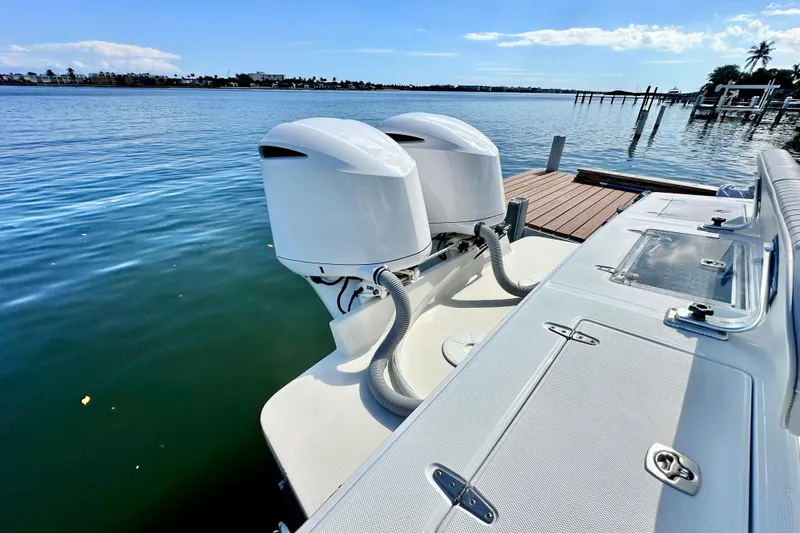  Yacht Photos Pics 2006 Jupiter 31FS boat with dual outboard motors docked by the water.
