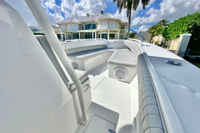  Yacht Photos Pics 2006 Jupiter 31FS boat interior with luxurious seating, set against a waterfront home backdrop.