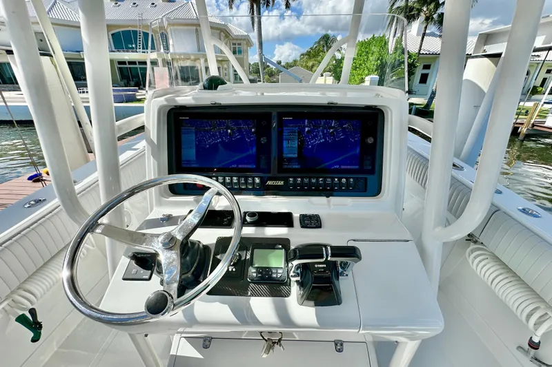  Yacht Photos Pics Steering console of a 2006 Jupiter 31FS boat with navigation screens and controls.
