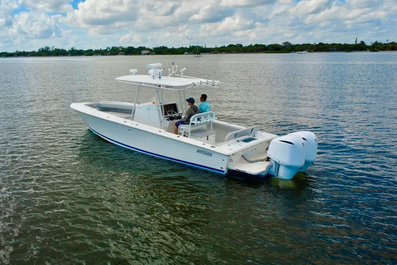  Yacht Photos Pics 2006 Jupiter 31FS boat on calm water under a partly cloudy sky.