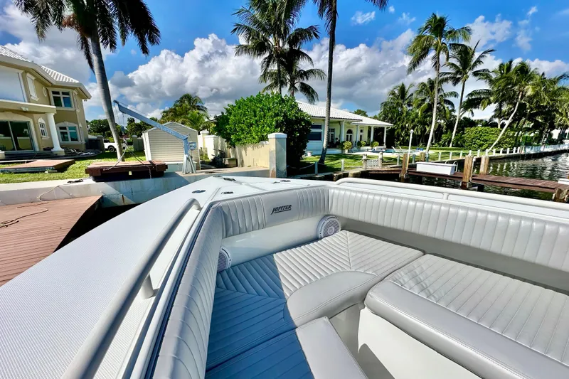  Yacht Photos Pics 2006 Jupiter 31FS boat docked by waterfront homes and palm trees under a blue sky.