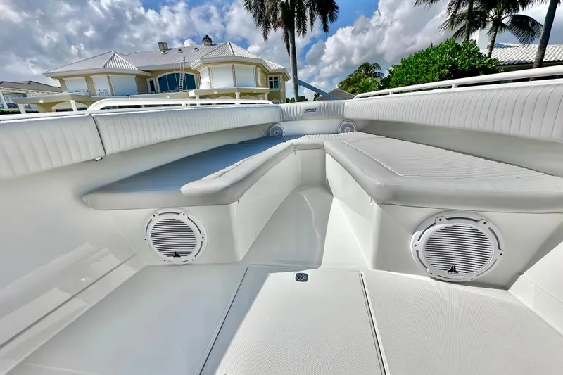  Yacht Photos Pics Luxurious 2006 Jupiter 31FS boat interior with cushioned seating and speakers, under a sunny sky.