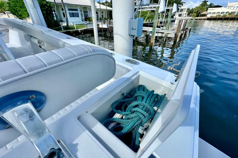  Yacht Photos Pics 2006 Jupiter 31FS boat with open storage compartment, docked by waterfront homes.