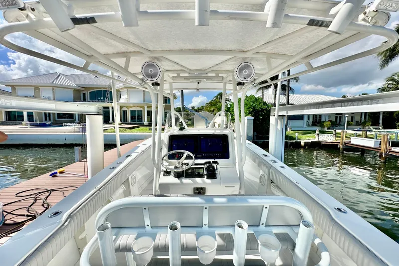  Yacht Photos Pics 2006 Jupiter 31FS boat interior with steering console, docked by waterfront homes.