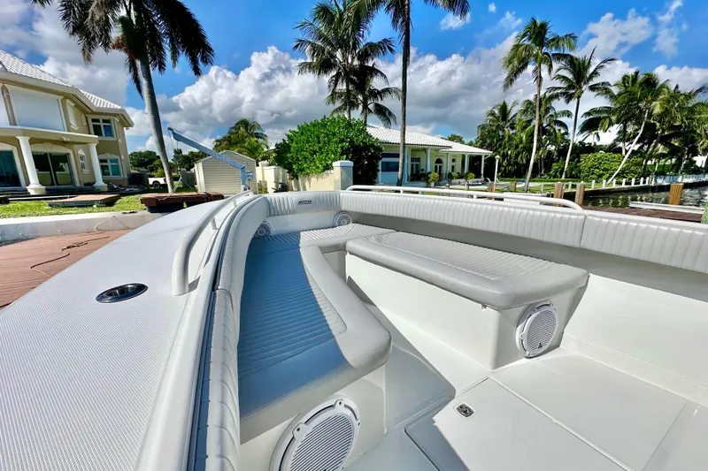  Yacht Photos Pics 2006 Jupiter 31FS boat interior with luxurious seating, docked near palm trees and waterfront homes.