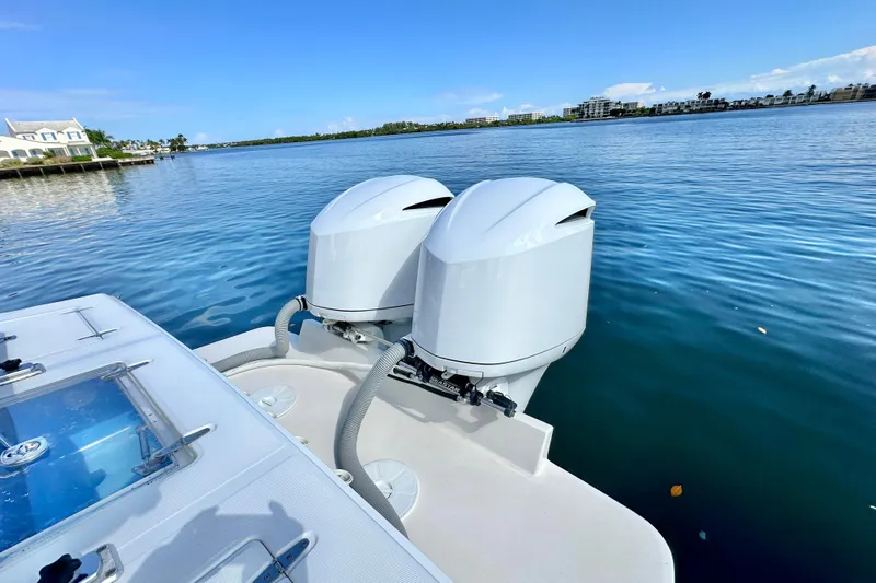  Yacht Photos Pics 2006 Jupiter 31FS boat with dual outboard motors on a calm waterway.