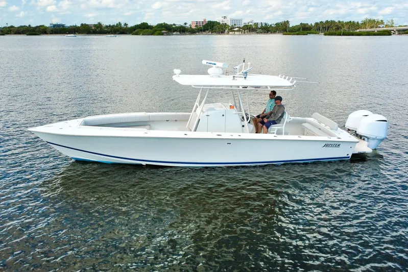  Yacht Photos Pics 2006 Jupiter 31FS boat on calm water with two people onboard.