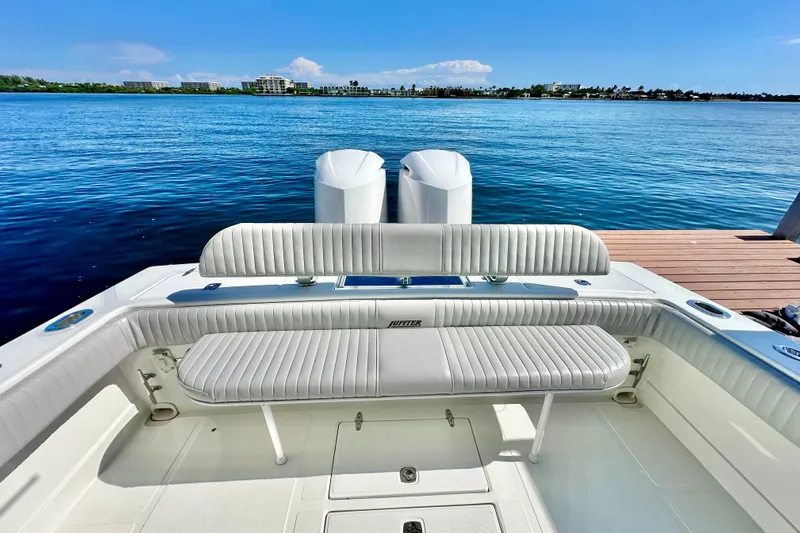  Yacht Photos Pics 2006 Jupiter 31FS boat with white seating, docked by a serene blue lake.