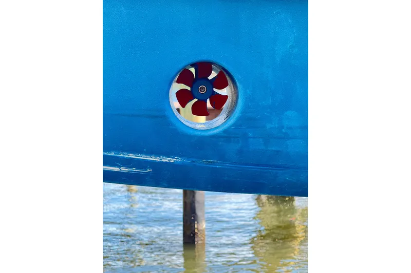  Yacht Photos Pics Close-up of a 2006 Jupiter 31FS boat's red propeller against blue hull.