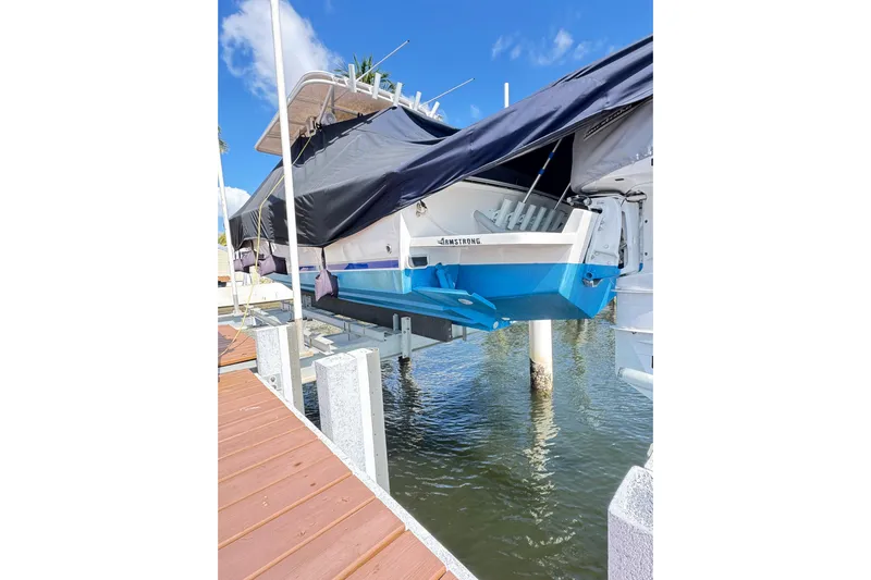  Yacht Photos Pics 2006 Jupiter 31FS boat on lift, covered, dockside view, clear blue sky.