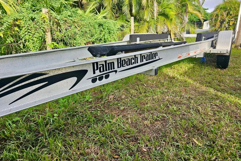  Yacht Photos Pics Trailer labeled "Palm Beach Trailer" on grass, surrounded by lush greenery.