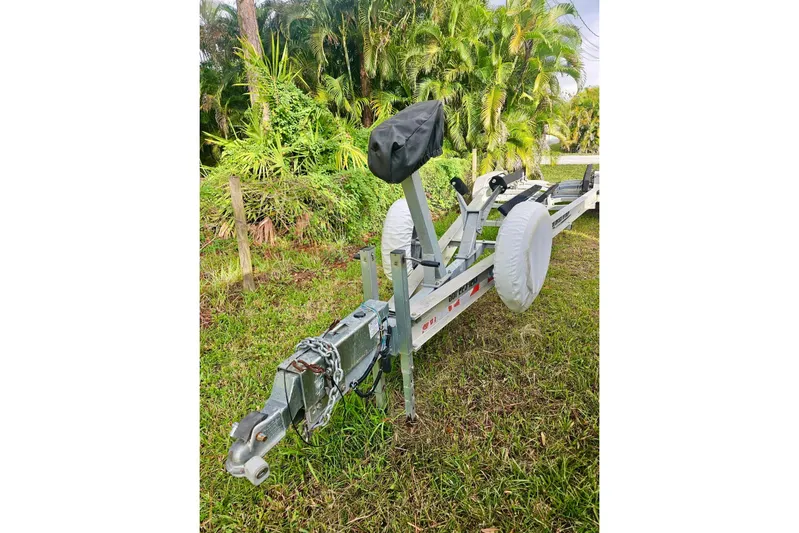  Yacht Photos Pics Trailer for 2006 Jupiter 31FS boat, parked on grass with lush greenery background.