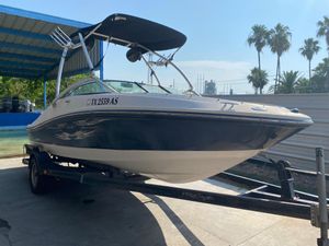 2008 Sea Ray 185 Sport boat on trailer, under a canopy, with palm trees in background.