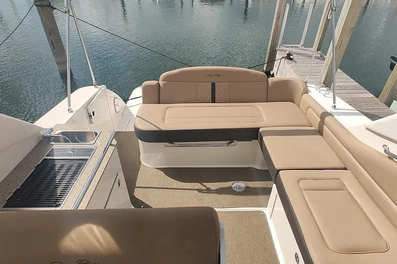  Yacht Photos Pics 2017 Sea Ray Sundancer 310 boat interior with beige seating and kitchenette by the water.