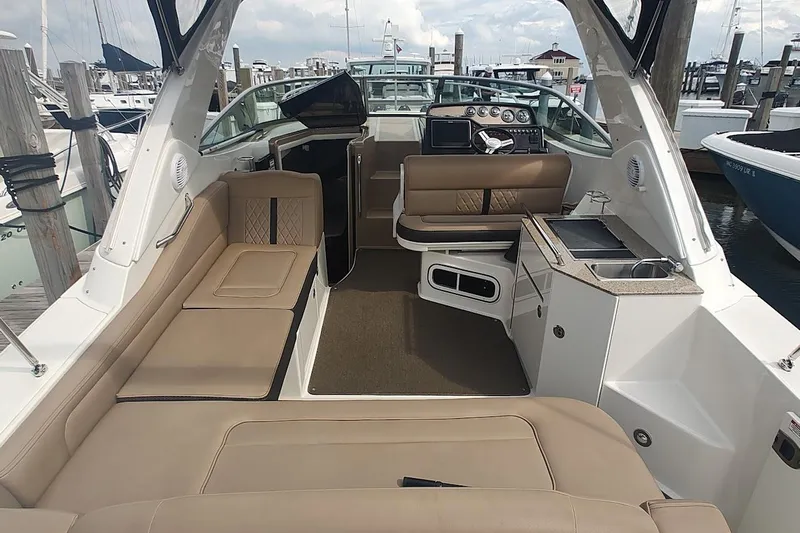  Yacht Photos Pics 2017 Sea Ray Sundancer 310 interior with beige seating and helm at marina.