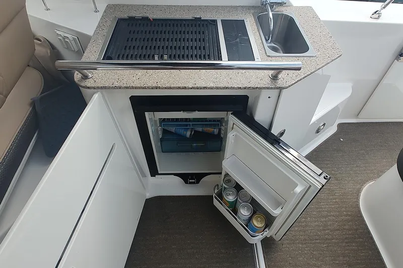  Yacht Photos Pics 2017 Sea Ray Sundancer 310 boat kitchenette with grill, sink, and open mini fridge.
