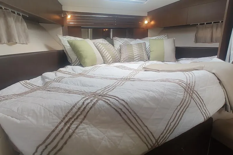  Yacht Photos Pics Cozy cabin interior of 2017 Sea Ray Sundancer 310 with plush bedding and pillows.