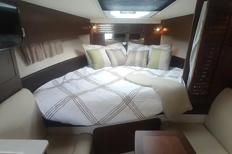  Yacht Photos Pics Luxurious cabin interior of 2017 Sea Ray Sundancer 310 with cozy bedding and modern decor.