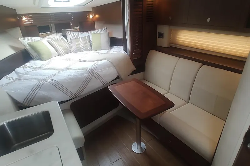  Yacht Photos Pics Luxurious interior of 2017 Sea Ray Sundancer 310 with cozy bed and seating area.