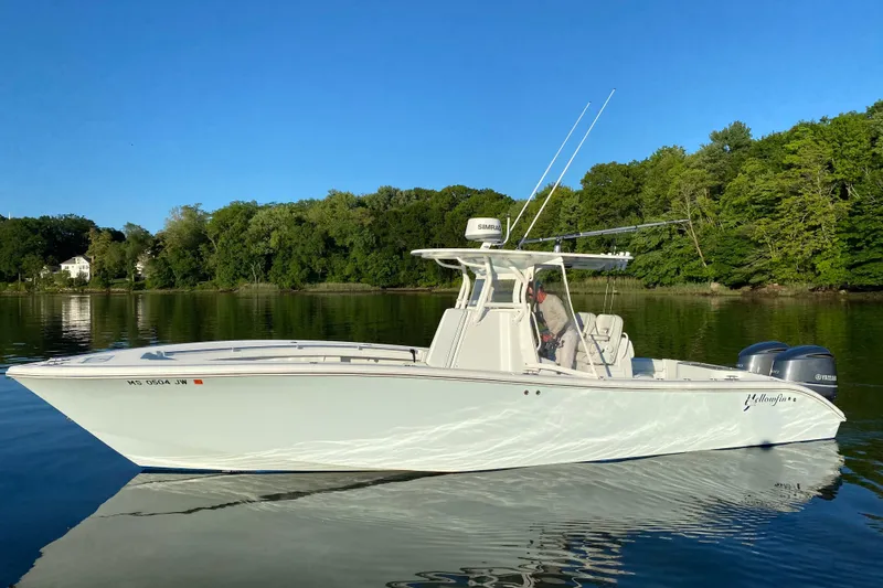 Salty Dog 2 Yacht Photos Pics 2013 Yellowfin 32 boat on calm water with lush green shoreline.