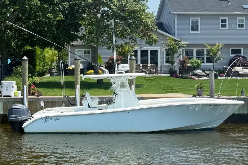 Salty Dog 2 Yacht Photos Pics 2013 Yellowfin 32 boat docked by a waterfront home with lush greenery.