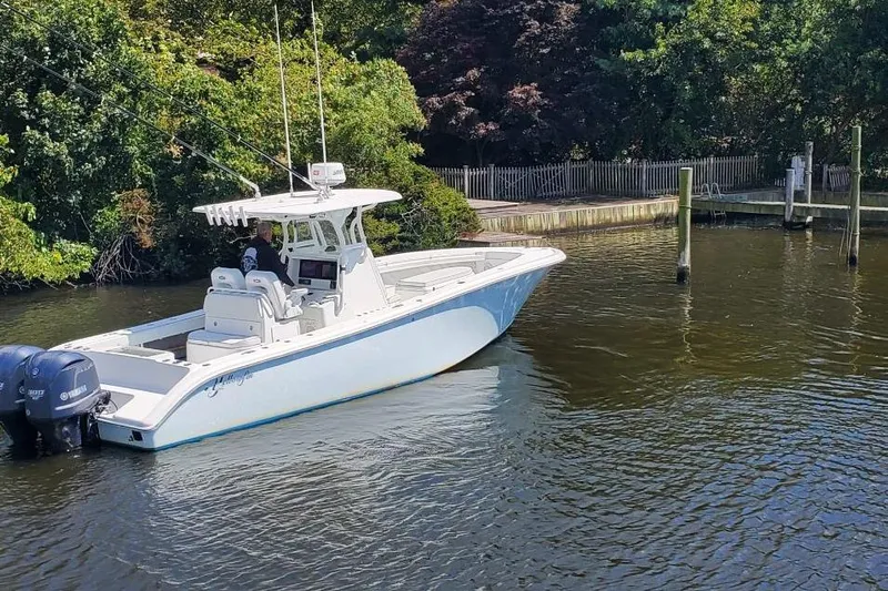 Salty Dog 2 Yacht Photos Pics 2013 Yellowfin 32 boat with dual engines on a calm river near a wooded shoreline.