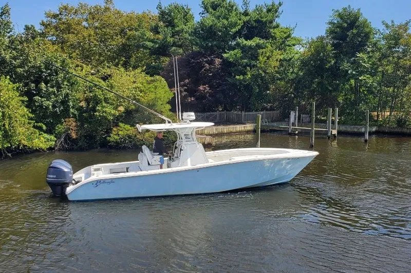 Salty Dog 2 Yacht Photos Pics 2013 Yellowfin 32 boat on calm water, surrounded by lush greenery.
